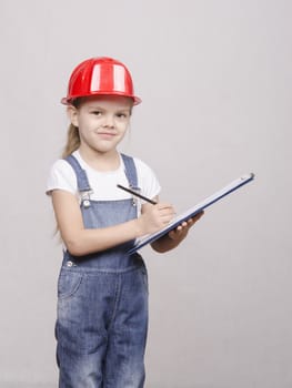 Girl engineer is a helmet folder and writes in folder