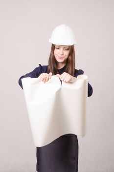 Young woman architect in helmet drawing tears