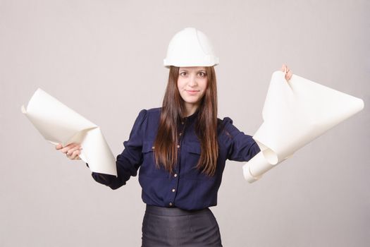 Young woman architect in helmet drawing tears