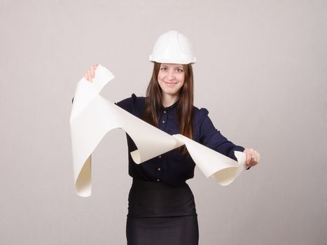 Young woman architect in helmet drawing tears