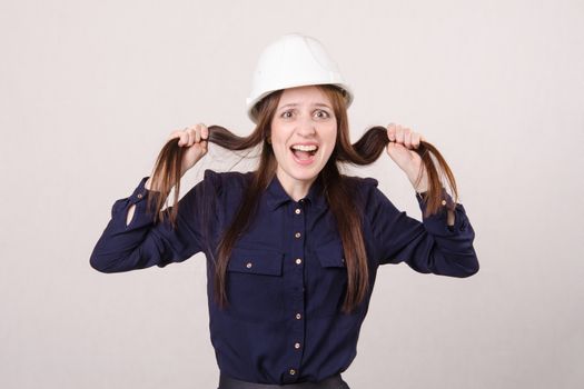 Portrait of a young beautiful girl engineer, architect in helmet