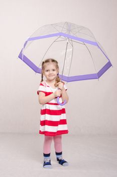 Portrait of a three-year girl in a summer dress with umbrella