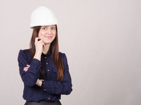 Portrait of a young beautiful girl engineer, architect in helmet