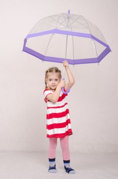 Portrait of a three-year girl in a summer dress with umbrella