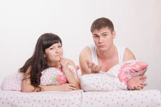 Young beautiful couple are thinking about the problems lying in bed