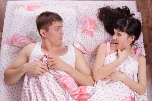 Unfamiliar young girl and the guy awake in bed
