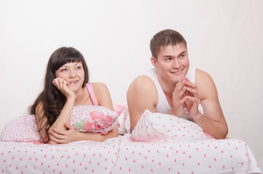 Young beautiful couple are thinking about the problems lying in bed