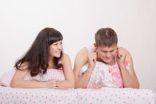 Young family couple quarrels in a bed