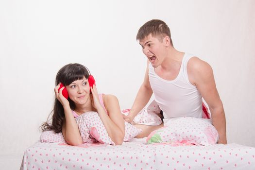 Young family couple quarrels in a bed