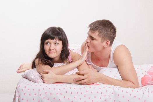 Young boy pesters girl in a bed
