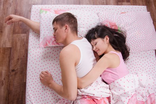 the young couple sleeping in the bed