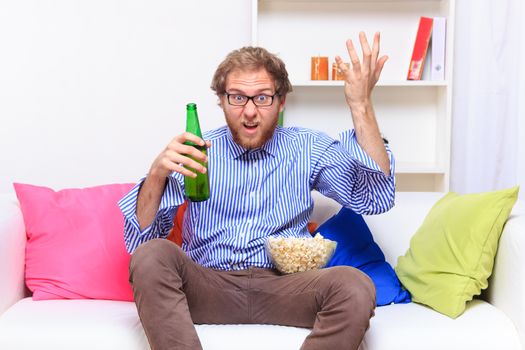 Dissatisfacted man on the couch when watching TV - studio shoot 