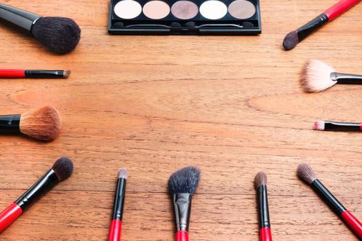 cosmetics and makeup brush, on wood table background
