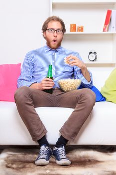 Surprised man in front of TV on the sofa 