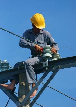 DONG THAP, VIET NAM- SEPT 23:  Asian electrician climb high in pole to work, lineman with cable network, man repair electric post danger and unsafe, is industry service, Vietnam, Sept 23, 2014