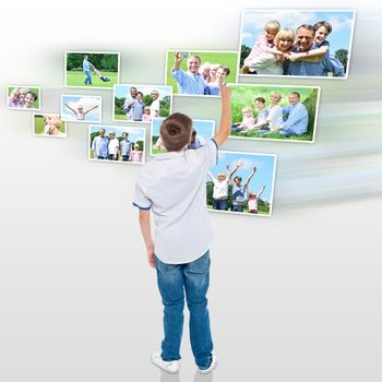 Rear view of boy looking his pictures in virtual screen