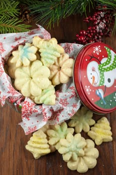 Christmas cookies in a decrative metal tin, sitting on a table.