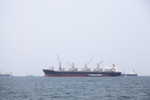 Large cargo ship Boats moored in the sea to make sense compared to the coast.