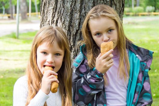 Photo of two eating girls in summer