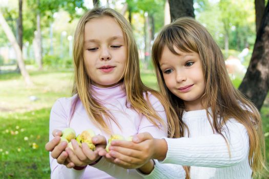 Photo of two girls with apples in summer