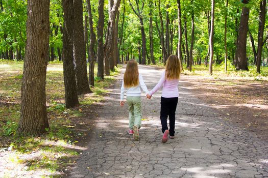 Photo of cute two girls walking in park