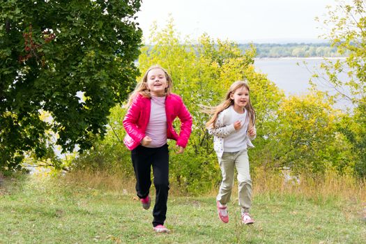 Photo of cute two running girls in summer