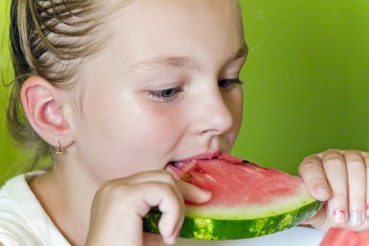 Photo of the cute girl eating watermelon