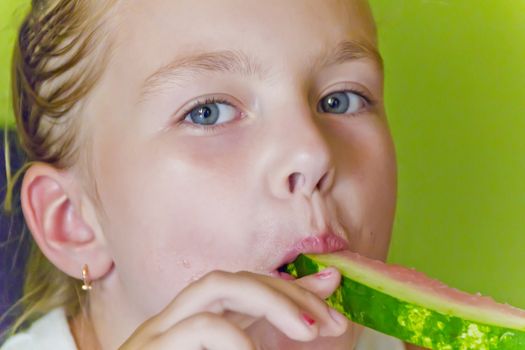Photo of the cute girl eating watermelon