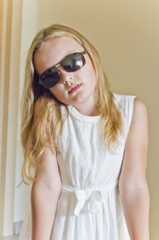 Photo of cute girl playing with sunglasses