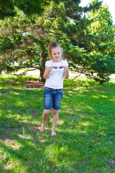 Cute girl playing with sunglasses in summer