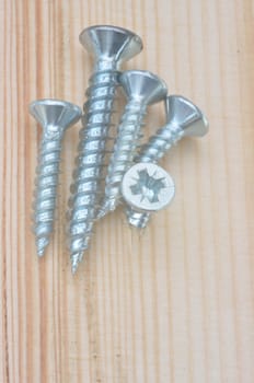 Group of screws on wooden background