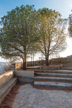 Cross between trees in a hill with stairs