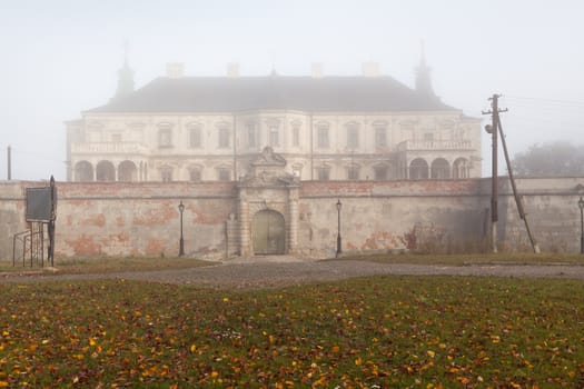 Ancient castle in the morning fog. Autumn season