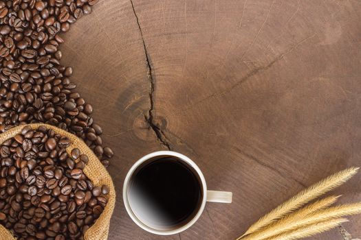 coffee cup and coffee beans on wood background