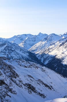 Tops of winter alp mountains at sunny day