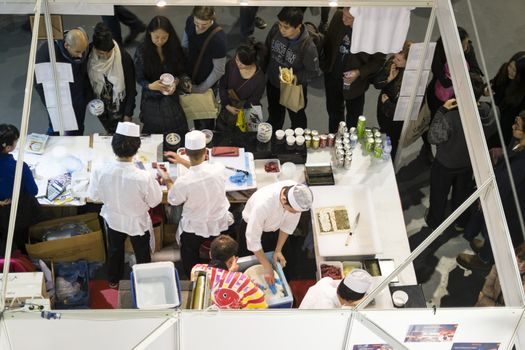 LONDON UK - NOVEMBER 15: High angle shot of sushi chefs working in stall in Hyper Japan. November 15, 2014 in London. Held in Kensington Olympia this year, the event celebrates all things Japanese.