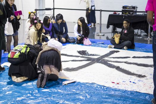 LONDON UK - NOVEMBER 15: Participants take part in Japanese caligraphy in Hyper Japan. November 15, 2014 in London. Held in Kensington Olympia this year, the event celebrates all things Japanese.