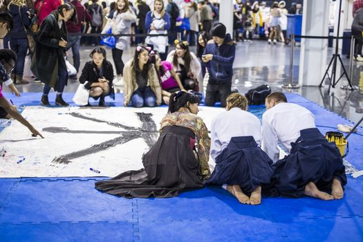 LONDON UK - NOVEMBER 15: Participants take part in Japanese caligraphy in Hyper Japan. November 15, 2014 in London. Held in Kensington Olympia this year, the event celebrates all things Japanese.