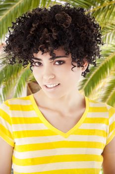 Young woman with curly hair and shirt with yellow stripes. Work Path.