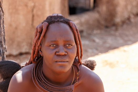 NAMIBIA, KAMANJAB, OCTOBER 10: Himba tribe woman with ornaments on the neck, in the village of Himba people near Kamanjab in northern Namibia, August 10, 2014, Namibia 