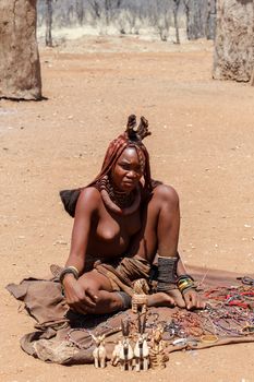 NAMIBIA, KAMANJAB, OCTOBER 10: Himba girl with souvenirs for sale in the Himba village in northern Namibia, near Kamanjab city, August 10, 2014, Namibia 