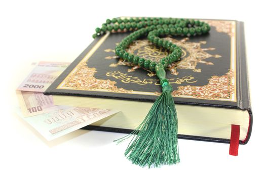 slammed Quran with Iranian currency before light background