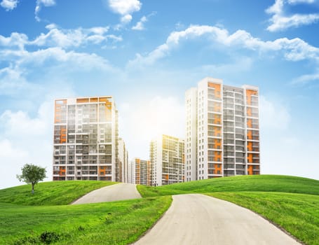 Tall buildings, green hills and road against sky with clouds. Architectural concept