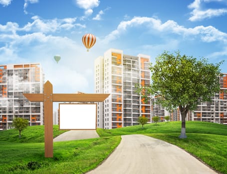 Buildings, green hills and road with wooden signboard against sky with clouds. Architectural concept