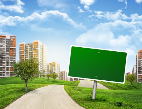 Buildings, green hills and road with empty road sign against sky with clouds. Business concept