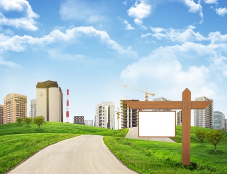 Buildings, green hills and road with wooden signboard against sky with clouds. Architectural concept