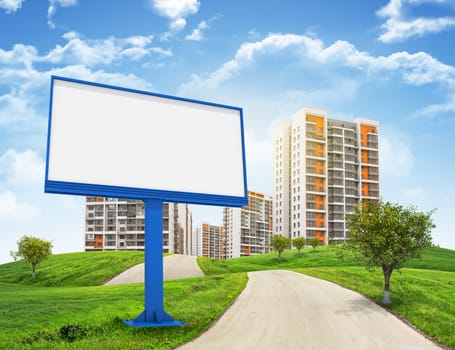 Tall buildings, green hills and road with large billboard against sky with clouds. Architectural concept