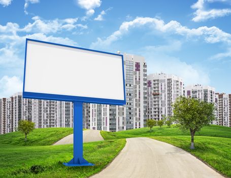 Tall buildings, green hills and road with large billboard against sky with clouds. Architectural concept