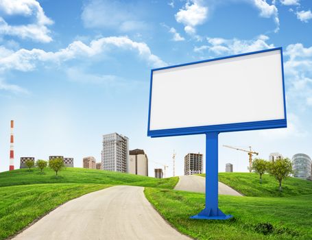 Tall buildings, green hills and road with large billboard against sky with clouds. Architectural concept