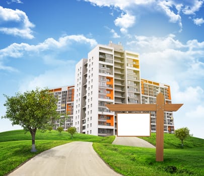 Buildings, green hills and road with wooden signboard against sky with clouds. Architectural concept